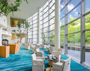 um átrio com cadeiras e mesas e janelas grandes em GRAND NIKKO AWAJI em Awaji