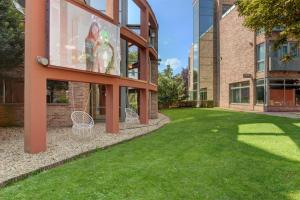 a building with a green lawn in front of it at Holiday Beach Budapest Wellness Hotel with Sauna Park in Budapest