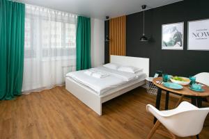 ノヴォシビルスクにあるApartments Domant Romanova 60/1のベッドルーム1室(白いベッド1台、テーブル、テーブル付)
