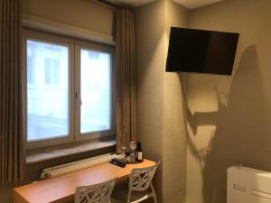 um quarto de hotel com uma mesa e uma janela em Hotel Duivels Paterke Harelbeeksestraat 29, 8500 Kortrijk em Kortrijk