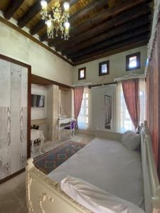 a bedroom with a large bed and a chandelier at Kasr-ı Canan in Halfeti