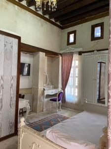 a bedroom with a bed and a desk and a table at Kasr-ı Canan in Halfeti