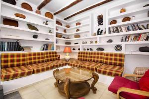 ein Wohnzimmer mit Sofas, einem Tisch und Regalen in der Unterkunft Casa Jardin ideal para familias in Arrecife