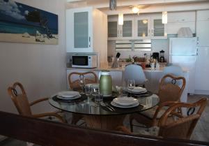 a dining room table with chairs and a kitchen at THE VILLAS ON GREAT BAY, Villa LAVINIA #9 in Philipsburg
