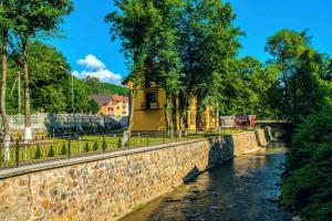 a building on a stone wall next to a river at Apartments in Polyana in Polyana