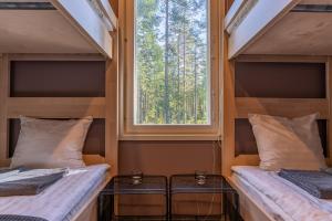 two beds in a tiny house with a window at Saimaa LIGHT in Imatra