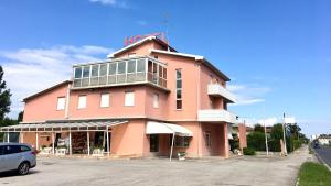a pink building with a sign on top of it at Hotel Trieste in San Giórgio di Nogaro