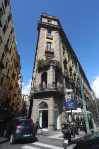 un edificio alto con coches estacionados frente a él en L'antico Borgo Angioino, en Nápoles