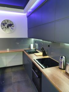 uma cozinha com um lavatório e um relógio na parede em Apartament Skarbowa 1 em Leszno