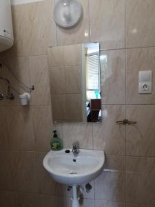uma casa de banho com um lavatório e um espelho em Vendégház Kalocsa em Kalocsa