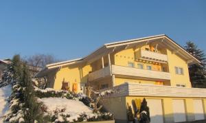 Una gran casa amarilla con nieve. en Haus Sonnenblick, en Lam