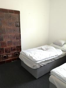 um quarto com 2 camas e uma parede de tijolos em Vendégház Kalocsa em Kalocsa