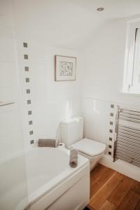 een witte badkamer met een toilet en een wastafel bij Anchor Cottage Noss Mayo in Plymouth +64 foto's