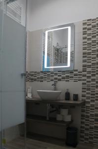W łazience znajduje się umywalka i lustro. w obiekcie Ben's Houses - Trastevere apartment w Rzymie