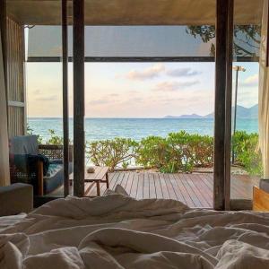 a bedroom with a bed and a view of the ocean at Casa De Mar - SHA Plus in Chaweng
