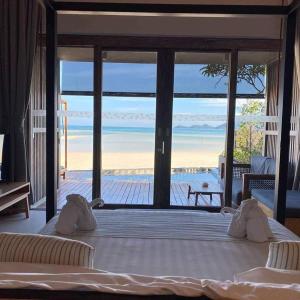 a bedroom with a bed with a view of the beach at Casa De Mar - SHA Plus in Chaweng