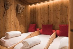 2 camas en una sauna con almohadas rojas en Park Hotel Villa Etschland, en Plaus