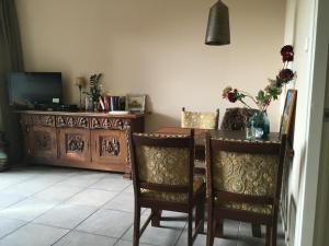 a dining room with a table and chairs and a television at it Annahûs in Allingawier