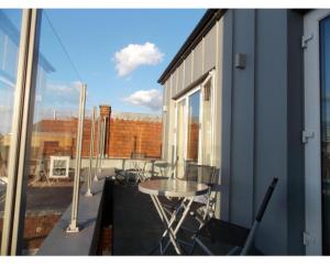 a balcony with a table and chairs and a window at Penthouse apartment in Basingstoke in Basingstoke