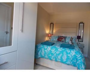 a bedroom with a bed with blue and white sheets at Penthouse apartment in Basingstoke in Basingstoke