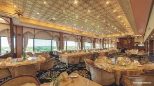 a dining car of a train with tables and chairs at Hotel Clarks Shiraz in Agra