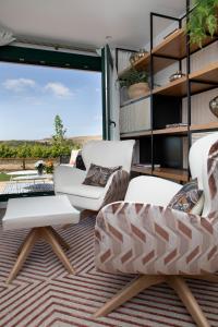 sala de estar con 2 sillas y mesa en Villas Finca La Emperatriz, en Baños de Rioja