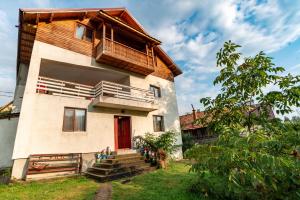 una casa con una porta rossa e un balcone di Surasul Muntelui a Dragoslavele