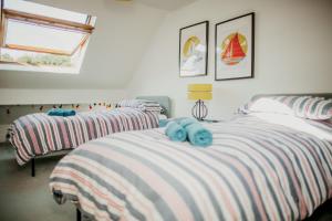 een slaapkamer met 2 bedden en blauwe handdoeken bij Anchor Cottage Noss Mayo in Plymouth