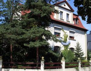 una casa bianca con una recinzione di fronte di Pension Liebert a Weissenfels