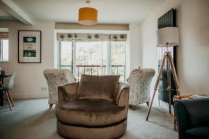 een woonkamer met een stoel en een raam bij Anchor Cottage Noss Mayo in Plymouth