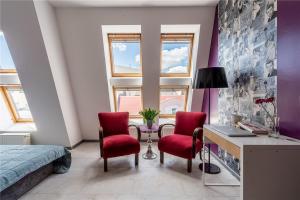 1 dormitorio con escritorio, 2 sillas y 1 cama en Apartament Broadway, en Poznan