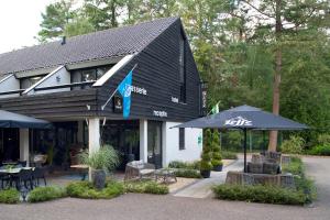 um restaurante com guarda-sóis em frente a um edifício em Bosrijk Ruighenrode em Lochem