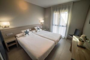 Posteľ alebo postele v izbe v ubytovaní Apartamentos Santa Clara