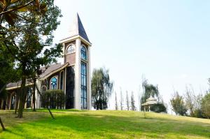 a church with a clock tower on a grassy hill at Crowne Plaza Chengdu Panda Garden, an IHG Hotel in Chengdu