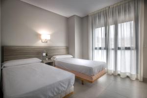 Posteľ alebo postele v izbe v ubytovaní Apartamentos Santa Clara
