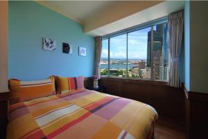 a bedroom with a colorful bed and a large window at Jia Jia House in Kaohsiung