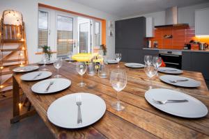 een houten tafel met witte borden en wijnglazen bij higgihaus #3b 4 Bed Monday - Friday Whole House in Bristol