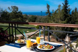 a table with two plates of food and drinks on a balcony at Korineum Golf & Beach Resort in Kyrenia