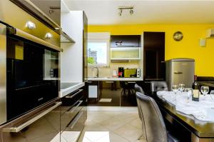 a kitchen with a dining table and yellow walls at Apartments Melita in Trogir