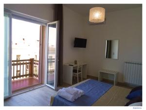 a bedroom with a bed and a large sliding glass door at Faro Bianco Gallipoli Dependance in Gallipoli