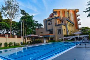 een gebouw met een zwembad voor een gebouw bij Admas Grand Hotel in Entebbe