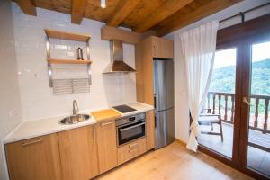 uma cozinha com um lavatório e um fogão e uma varanda em Apartamentos Los Picos de Europa em Colio