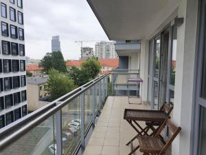 a balcony with a chair and a view of a city at NotaBene Wola Apartment in Warsaw