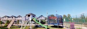 a playground with a slide and a play structure at Lawendowe domki in Karwia