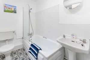 a white bathroom with a sink and a toilet at Comfortable Liverpool Townhouse - FREE parking in Liverpool