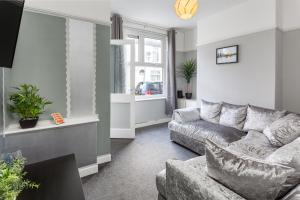 a living room with a couch and a window at Comfortable Liverpool Townhouse - FREE parking in Liverpool