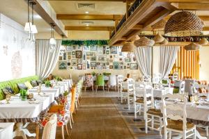 un comedor con mesas blancas y sillas blancas en Syktyvkar Hotel, en Syktyvkar