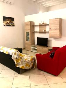a living room with a red couch and a tv at Casa Francesca in Carloforte