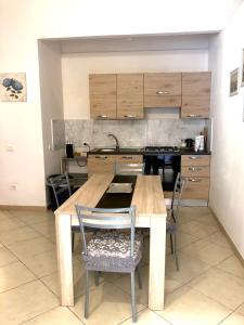 kuchnia z drewnianym stołem i krzesłami w obiekcie Casa Francesca w mieście Carloforte
