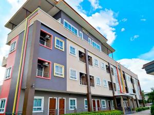 a building with colorful doors and windows on a street at LeMae Residence เลอเม เรสซิเดนซ์ อำเภอเขาย้อย เพชรบุรี in Ban Huai Krathaek